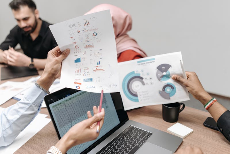 Hands working with charts and reports during a meeting
